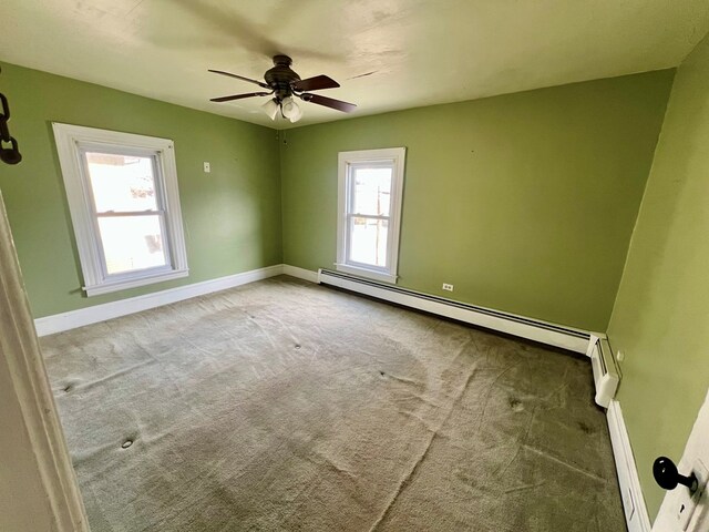 carpeted spare room with baseboard heating and ceiling fan