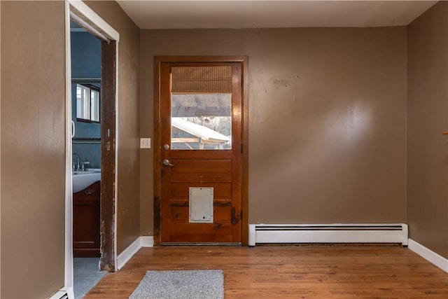 entryway featuring baseboards, light wood finished floors, and baseboard heating