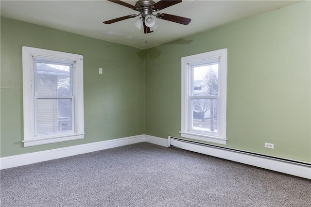 empty room with baseboards, carpet, a baseboard heating unit, and a wealth of natural light