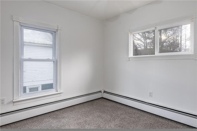 carpeted spare room featuring baseboard heating