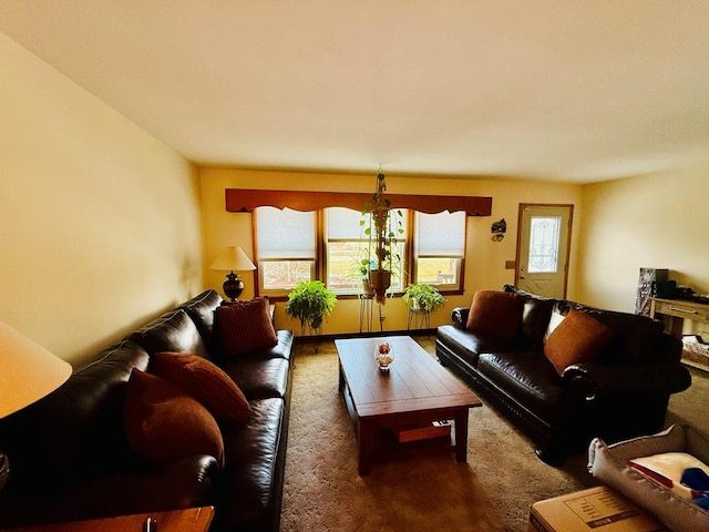 living room with plenty of natural light and dark colored carpet