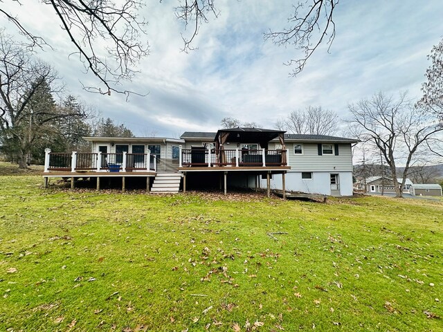 rear view of house with a yard and a deck