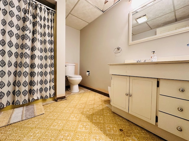 bathroom featuring vanity, a paneled ceiling, curtained shower, and toilet