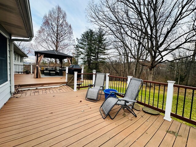 deck featuring a gazebo, an outdoor living space, and a lawn