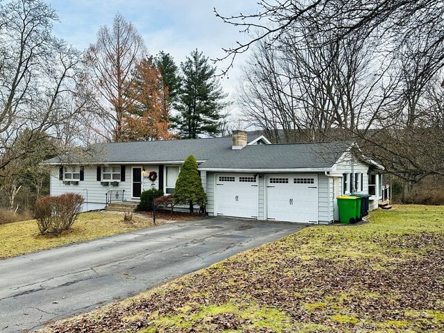 single story home with a garage and a front lawn