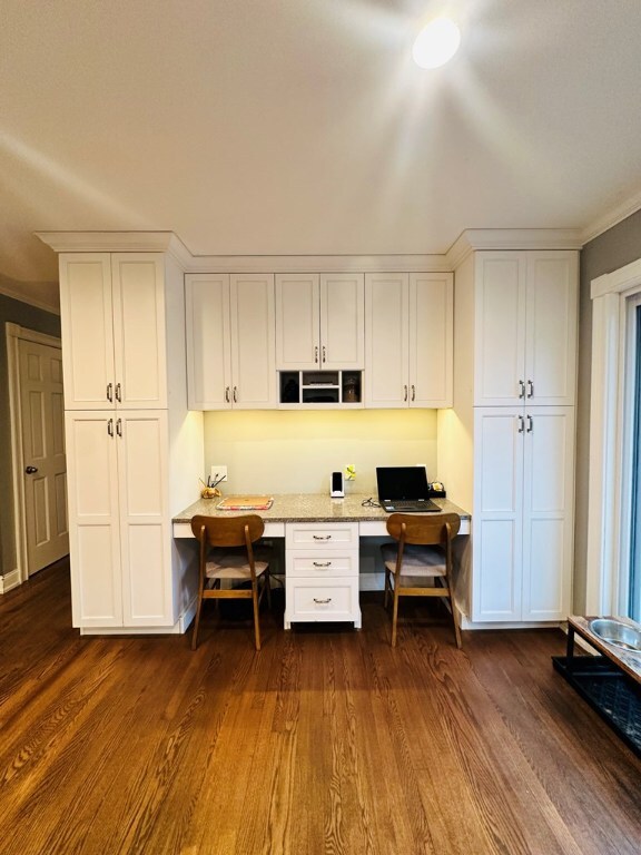 office area with crown molding, built in desk, and dark hardwood / wood-style floors