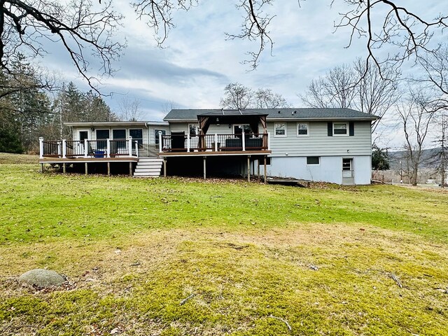 back of house with a deck and a lawn