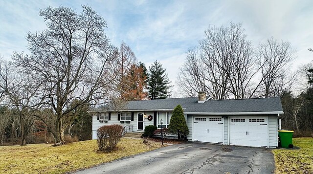 ranch-style house with a garage and a front lawn