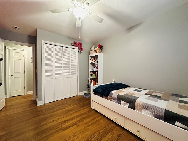 bedroom featuring ceiling fan, dark hardwood / wood-style flooring, and a closet