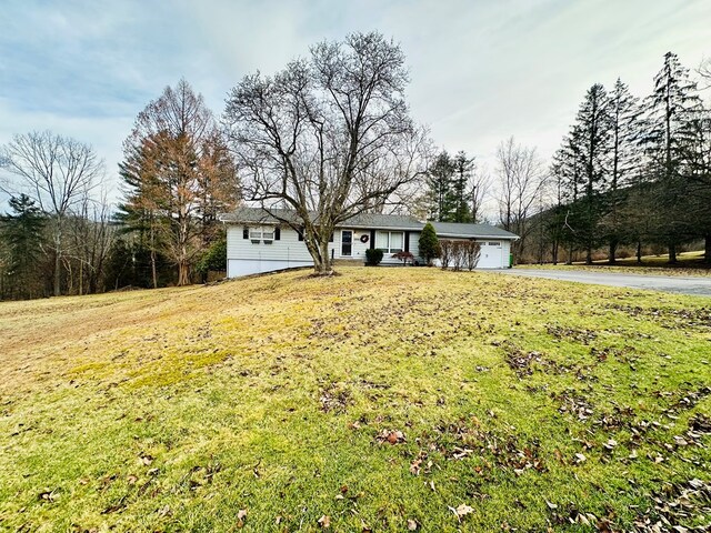 ranch-style house featuring a garage and a front yard