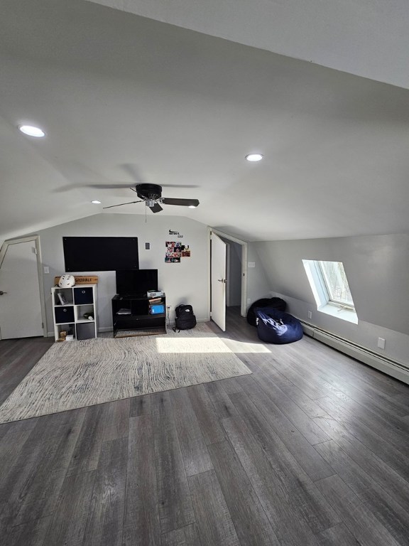 bonus room featuring dark wood-type flooring, a baseboard radiator, and vaulted ceiling with skylight