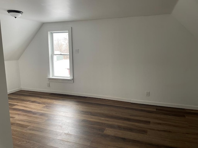 bonus room with dark wood-type flooring and lofted ceiling