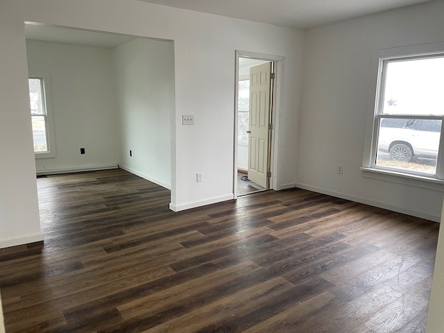 empty room featuring a baseboard radiator and dark hardwood / wood-style flooring