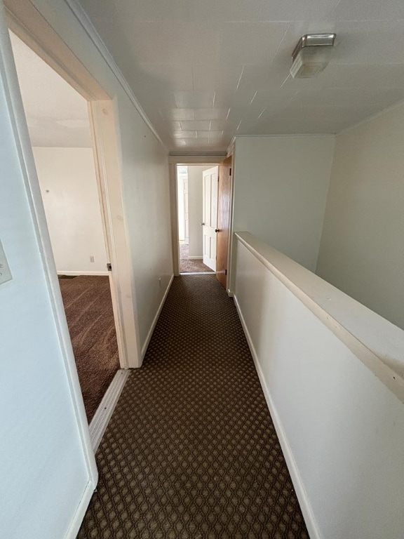 hall featuring dark carpet and ornamental molding