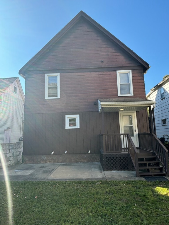 rear view of house featuring a yard