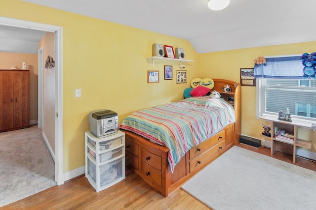 bedroom featuring lofted ceiling and light wood-type flooring