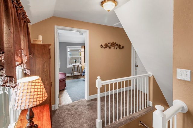 hallway featuring lofted ceiling and carpet