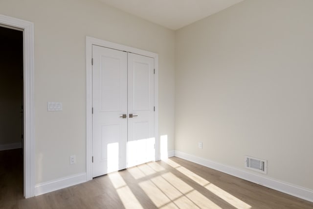 unfurnished bedroom featuring a closet and light hardwood / wood-style flooring