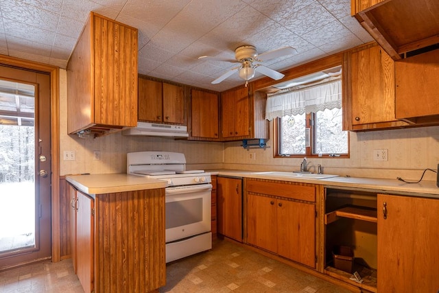 kitchen with white range oven, sink, and ceiling fan