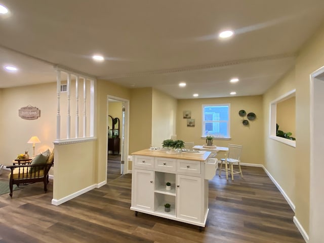 kitchen with dark hardwood / wood-style flooring, wooden counters, white cabinets, and a kitchen island