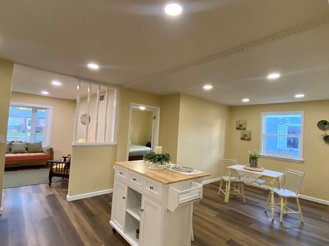 kitchen featuring white cabinetry, a center island, dark wood-type flooring, and wood counters