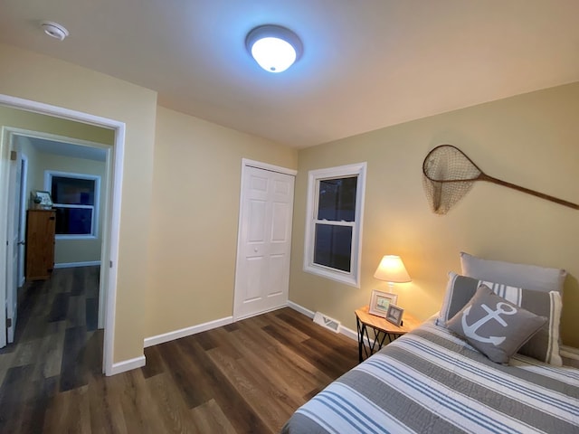 bedroom with dark wood-type flooring and a closet