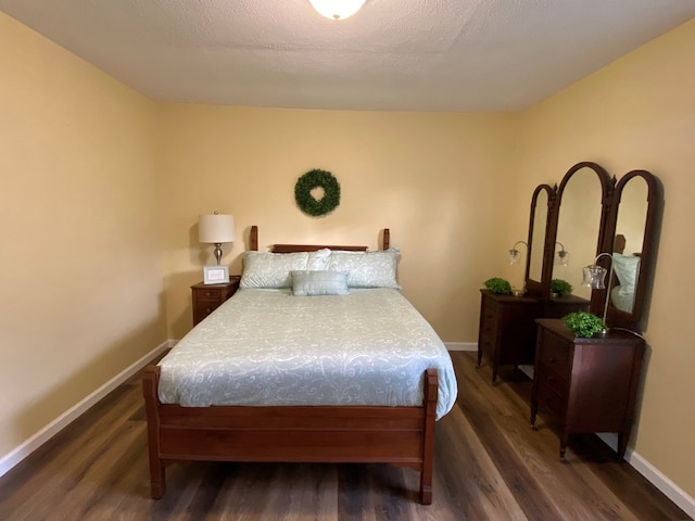 bedroom with dark wood-type flooring and a textured ceiling