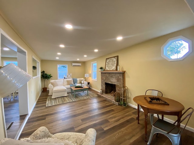 living room with dark hardwood / wood-style flooring, a wall mounted air conditioner, and a fireplace