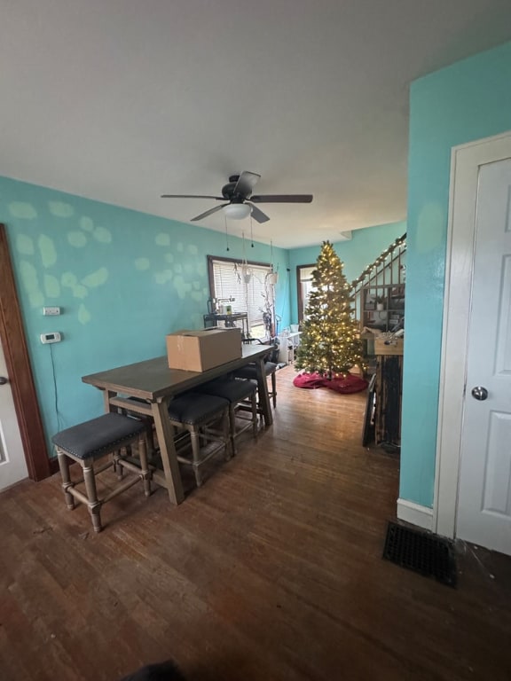 dining space with dark wood-type flooring and ceiling fan