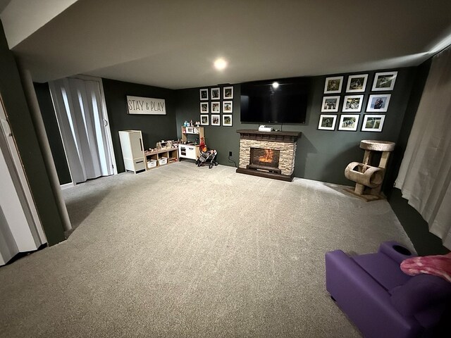 living area featuring carpet and a fireplace