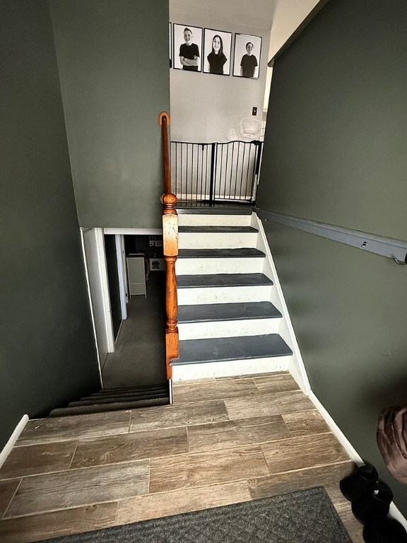 stairway with wood finish floors and baseboards