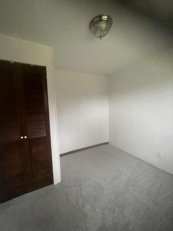 unfurnished room with dark colored carpet