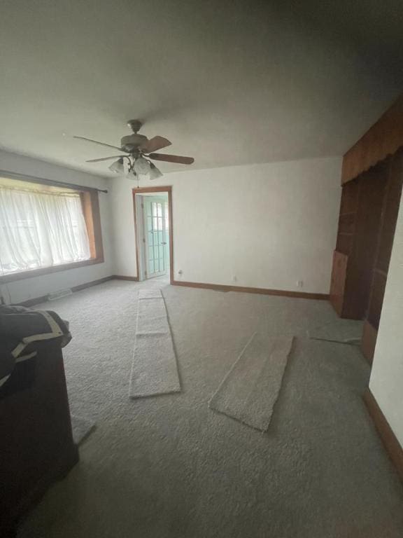 unfurnished room with ceiling fan and carpet flooring