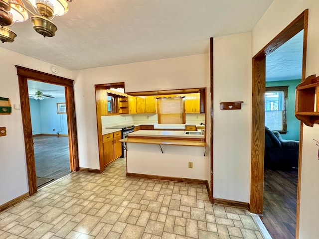 kitchen featuring sink, stainless steel electric stove, kitchen peninsula, and ceiling fan