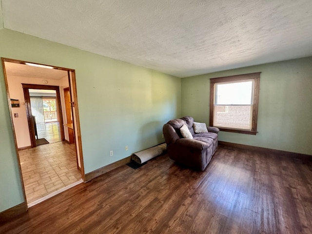 living area with dark hardwood / wood-style floors and a textured ceiling