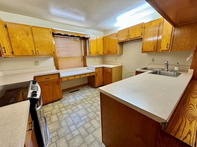 kitchen with stainless steel electric stove, sink, built in desk, and kitchen peninsula