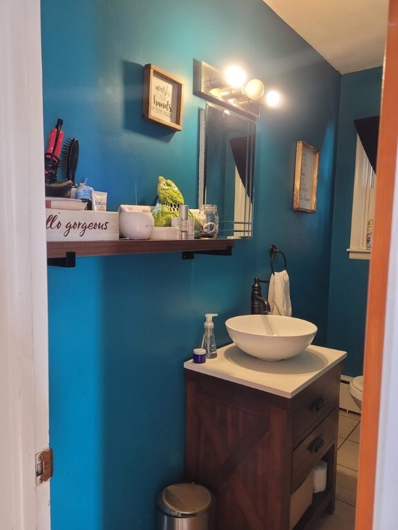 bathroom featuring tile patterned flooring, vanity, a baseboard radiator, and toilet