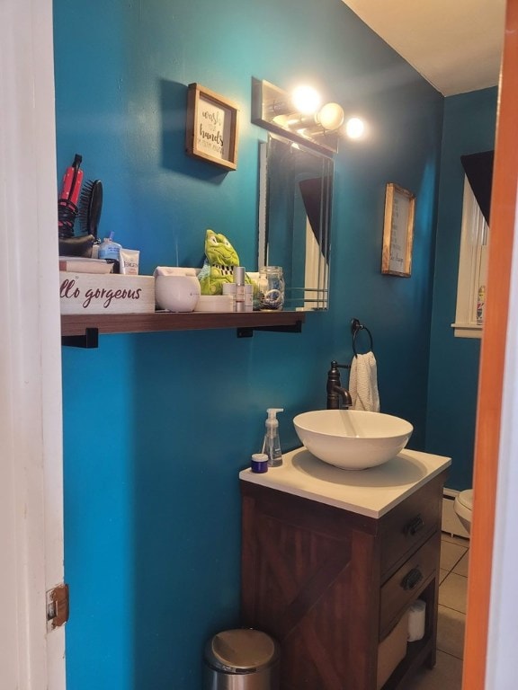 bathroom with tile patterned flooring, vanity, a baseboard radiator, and toilet