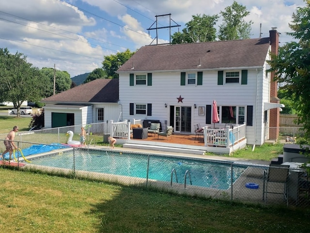 back of house featuring a swimming pool side deck and a lawn