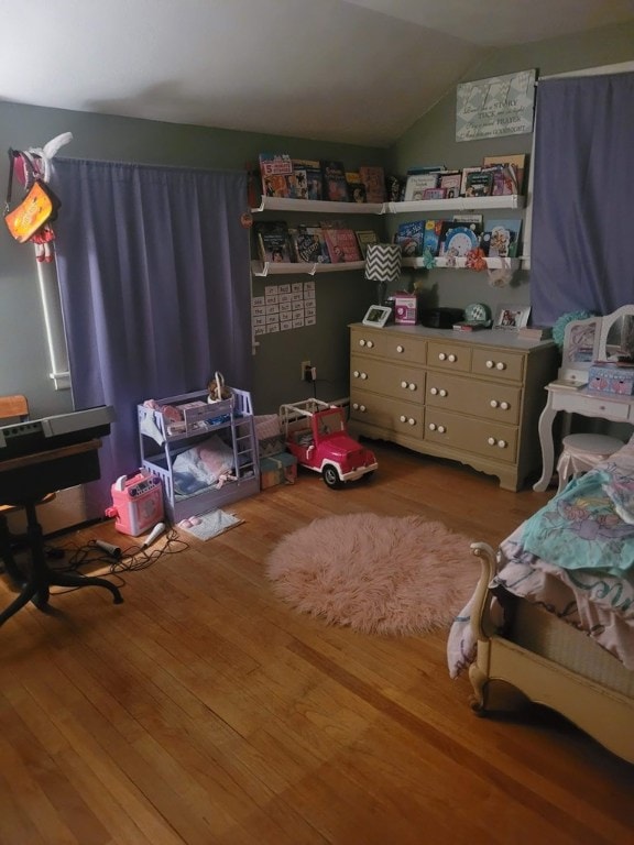 bedroom with vaulted ceiling and hardwood / wood-style floors