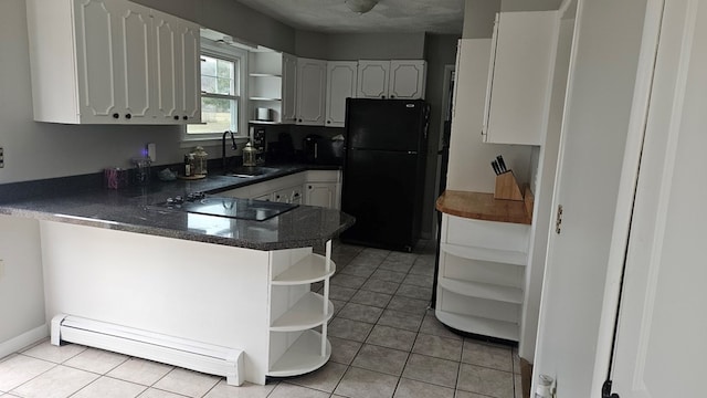 kitchen with black appliances, white cabinetry, sink, light tile patterned floors, and kitchen peninsula