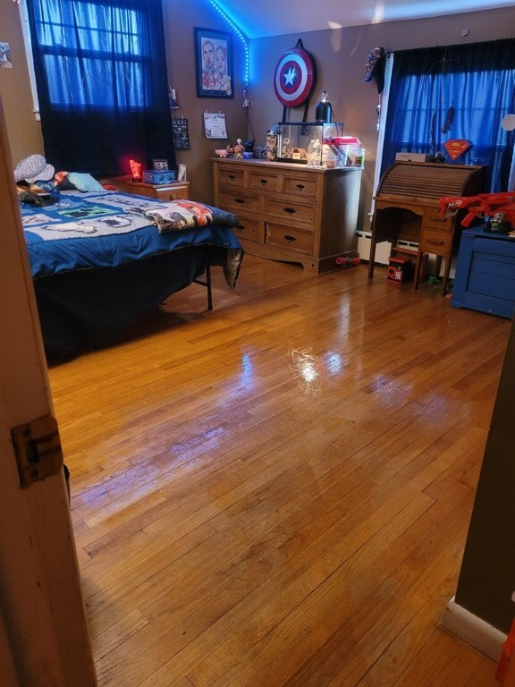 bedroom featuring hardwood / wood-style flooring and a baseboard radiator