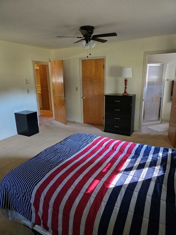 carpeted bedroom featuring ceiling fan and ensuite bathroom