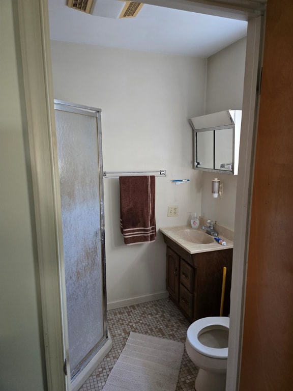 bathroom with walk in shower, tile patterned floors, toilet, and vanity