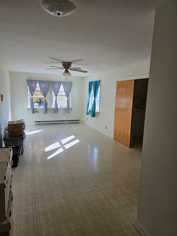 unfurnished living room with ceiling fan and a baseboard radiator