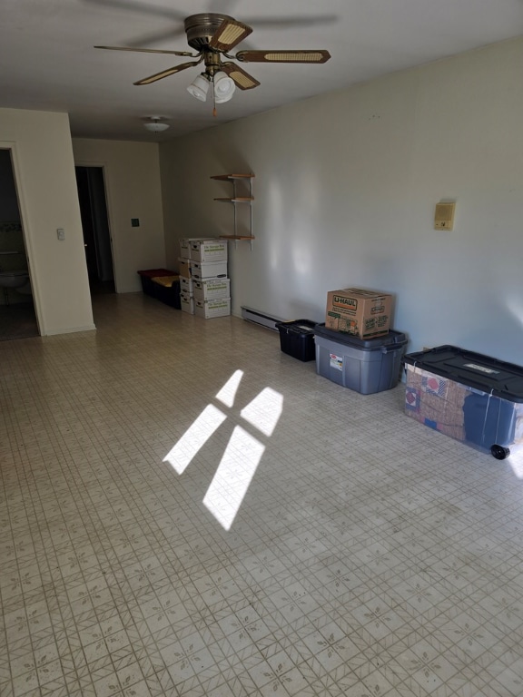 empty room with ceiling fan and a baseboard heating unit