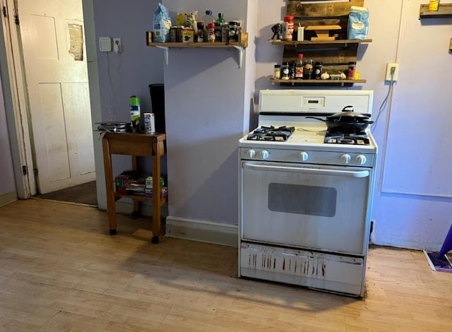 kitchen featuring white range with gas cooktop and light hardwood / wood-style floors