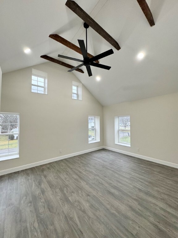 spare room with beam ceiling, wood-type flooring, and high vaulted ceiling