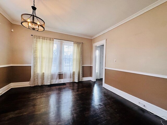 empty room with crown molding, a notable chandelier, and dark hardwood / wood-style flooring