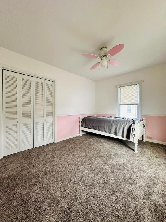 bedroom featuring ceiling fan, a closet, and carpet